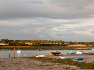 estuary scene in manningtree with moored boats tide clouds landscape