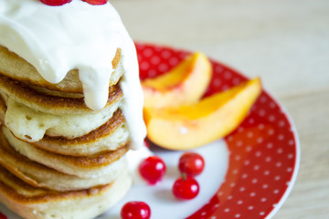Pancakes with sour cream, berries and fruit slices. Selective focus. 