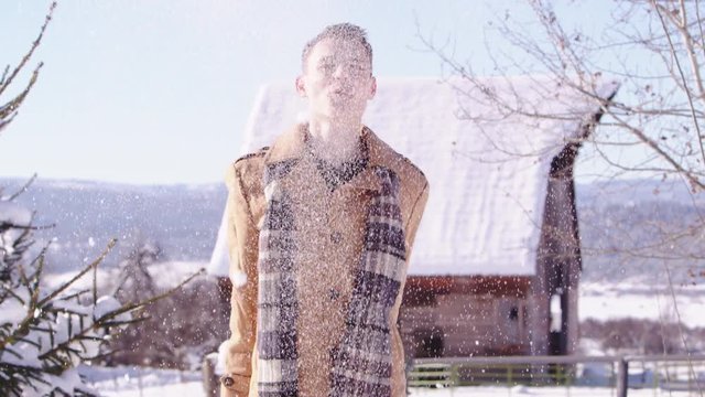 Slow motion young man throwing snow up in the air