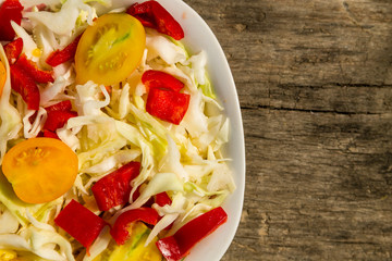 Fresh vegetable salad on rustic wooden table