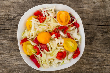 Fresh vegetable salad on rustic wooden table