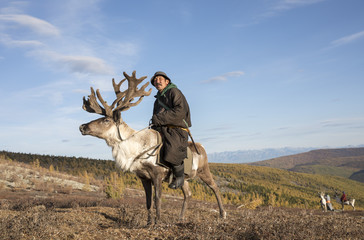 tsaatan man, dressed in a traditional deel, with his reindeer © katiekk2