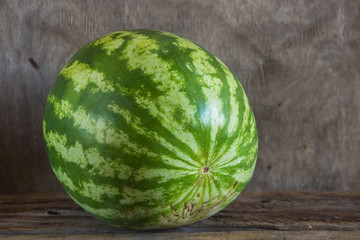Whole watermelon on the wooden background