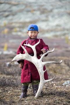 tsaatan nomadic boy in a traditional deel with a rein deer horn