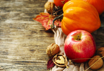 Autumn pumpkins and apples with fall leaves on wooden background with copy space. Autumn composition