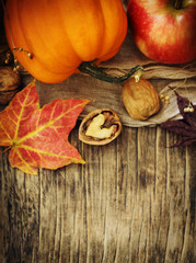 Autumn pumpkins and apples with fall leaves on wooden background with copy space. Autumn composition