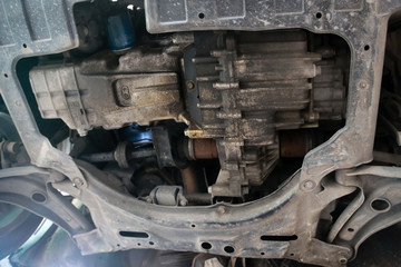 Photo from bottom view of car undercarriage in the garage shop.