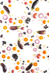 Composition of vegetables and fruits on a white background. Pattern made from fresh vegetables and fruits. Top view, flat design. Collage of red cabbage in a cut, eggplants, plums, grapes, mandarins.