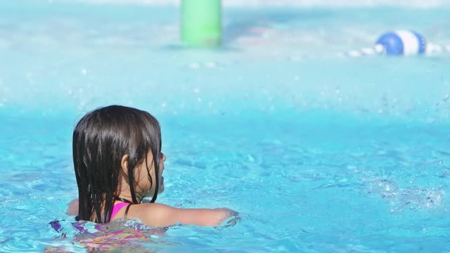Slow motion young girl playing in the pool