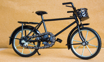Fototapeta na wymiar Bike black toy with Brown background