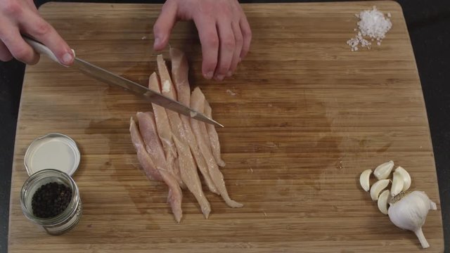 Cutting slices of chicken breast