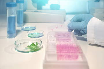 Scientific background with glass slide in gloved hand
