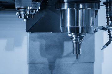 Close up of the CNC spindle with the cutting tool and holder in the light blue scene.The CNC machining center for hi-technology manufacturing.