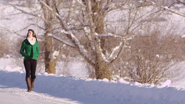 Young woman walking along a snowy path