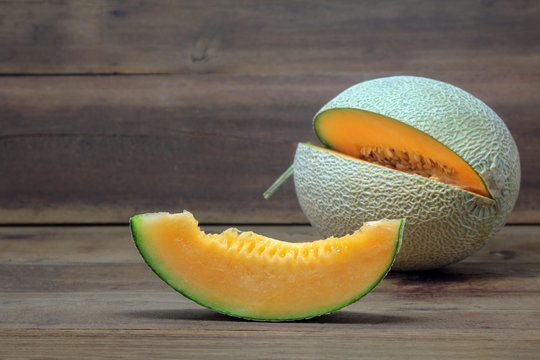 Orange Cantaloupe melon with sliced on wooden background, copy space for text.