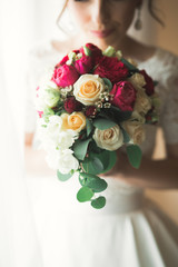 Luxury bride in white dress posing while preparing for the wedding ceremony