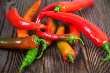 Hot red green chili peppers on wooden table