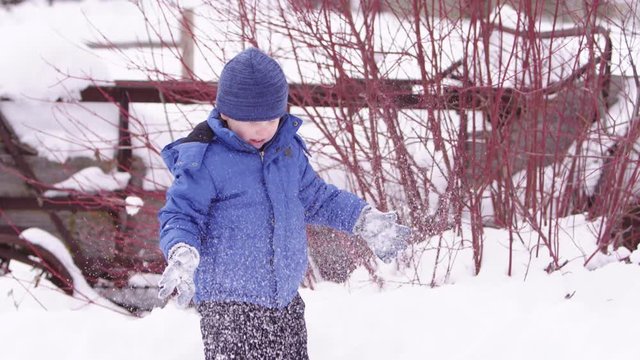 Young boy throwing snow in the air