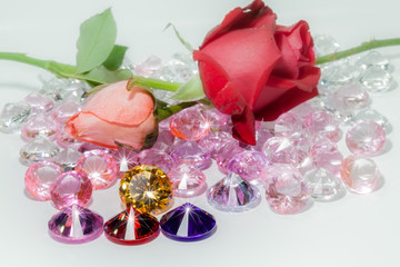 red rose and pink rose flowers are on the colorful gemstones.