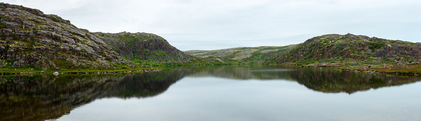 Fototapeta na wymiar Alpine lake on the coast of the Barents sea. Kola Peninsula, Russia.