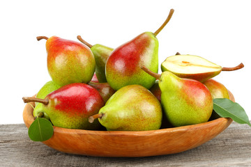 pear with leaf in wooden bowl on old wooden table with white background