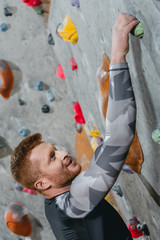 Man climbing wall with grips