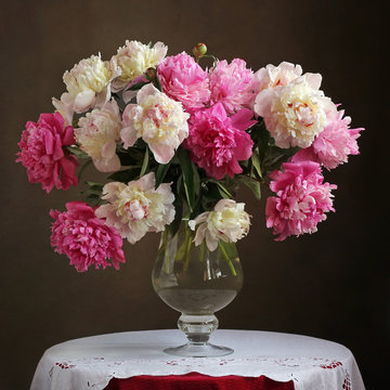 Fototapeta Lush bouquet of pink peonies in a vase on the table.