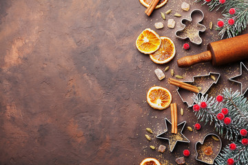 Holiday christmas background for baking cookies with cutters, rolling pin and spices on brown table top view. Copy space for text.
