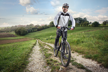 Fototapeta na wymiar Sportlicher Fahrradfahrer auf einem Feldweg