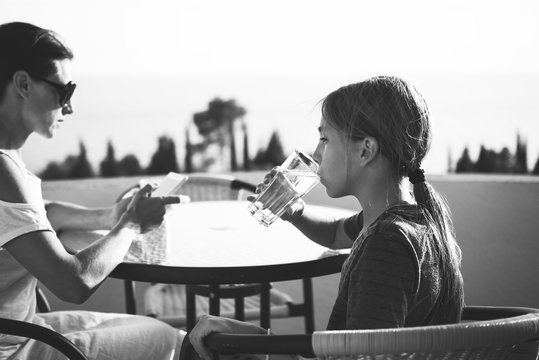 Girl sitting on balcony and drinking water
