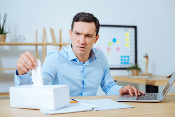 Attentive man looking at box with serviettes