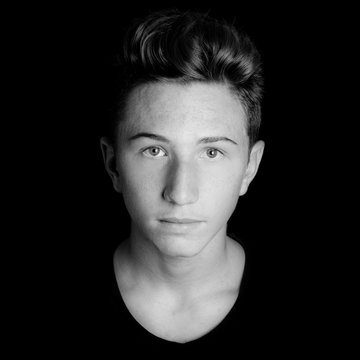 young guy serious portrait on black background - black and white photo
