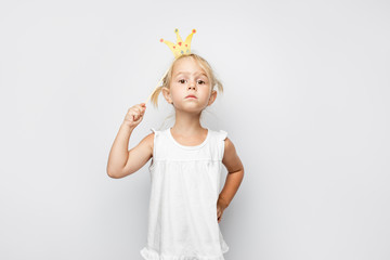 Beautiful little girl with paper crown posing on white backgroun