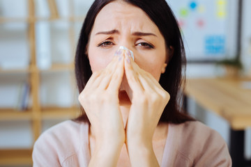 Portrait of sick woman that wiping nose