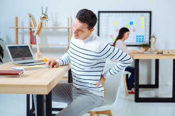 Serious man having pain in back