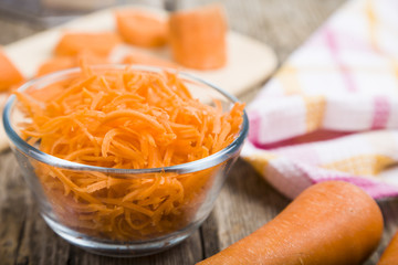 Grate  carrots in a bowl