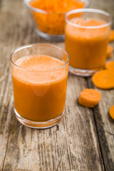 Carrot juice on a wooden table