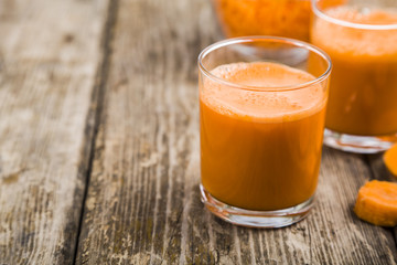 Carrot juice on a wooden table.