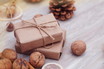 Christmas setting with wrapped gifts, traditional festive nuts and pine cones. Overhead view with copyspace