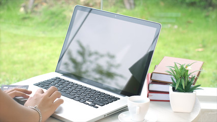 Behind of young woman typing on laptop