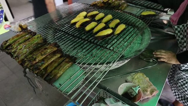 Footage of Local seller make roasted musa silver bluggoe banana at Sriyan market, Bangkok, Thailand