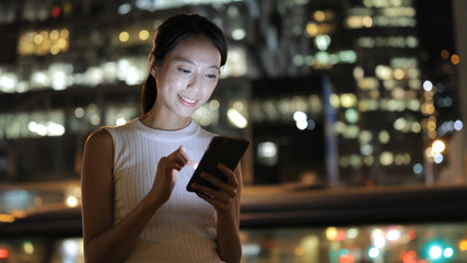 Woman working on cellphone at night