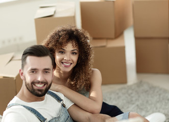 Fototapeta premium Young couple sitting on the floor in a new apartment