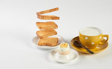 Flying toasts for breakfast and cup of fresh milk with chicken egg