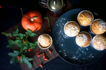 Homemade Lemon muffins with powdered sugar on a plate, on a dark background. Clothe up.