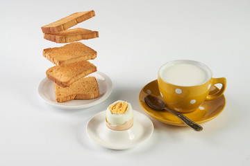 Flying toasts for breakfast and cup of fresh milk with chicken egg