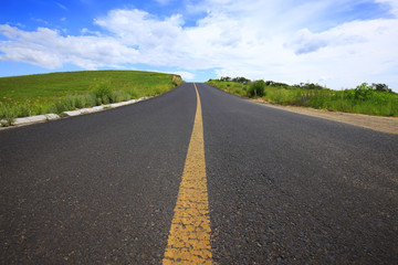 asphalt road on grassland