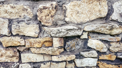 Stone old wall from huge blocks. Background of stones. The concept of reliability. The space between stones filled with cement.