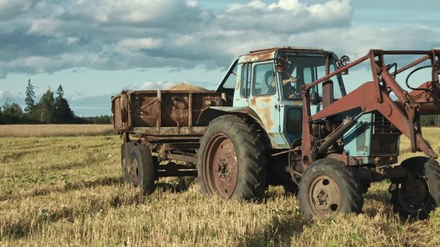 Old tractor and trailer filled with organic rye grains