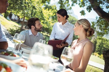 Waitress discussing the menu with customer in the restaurant